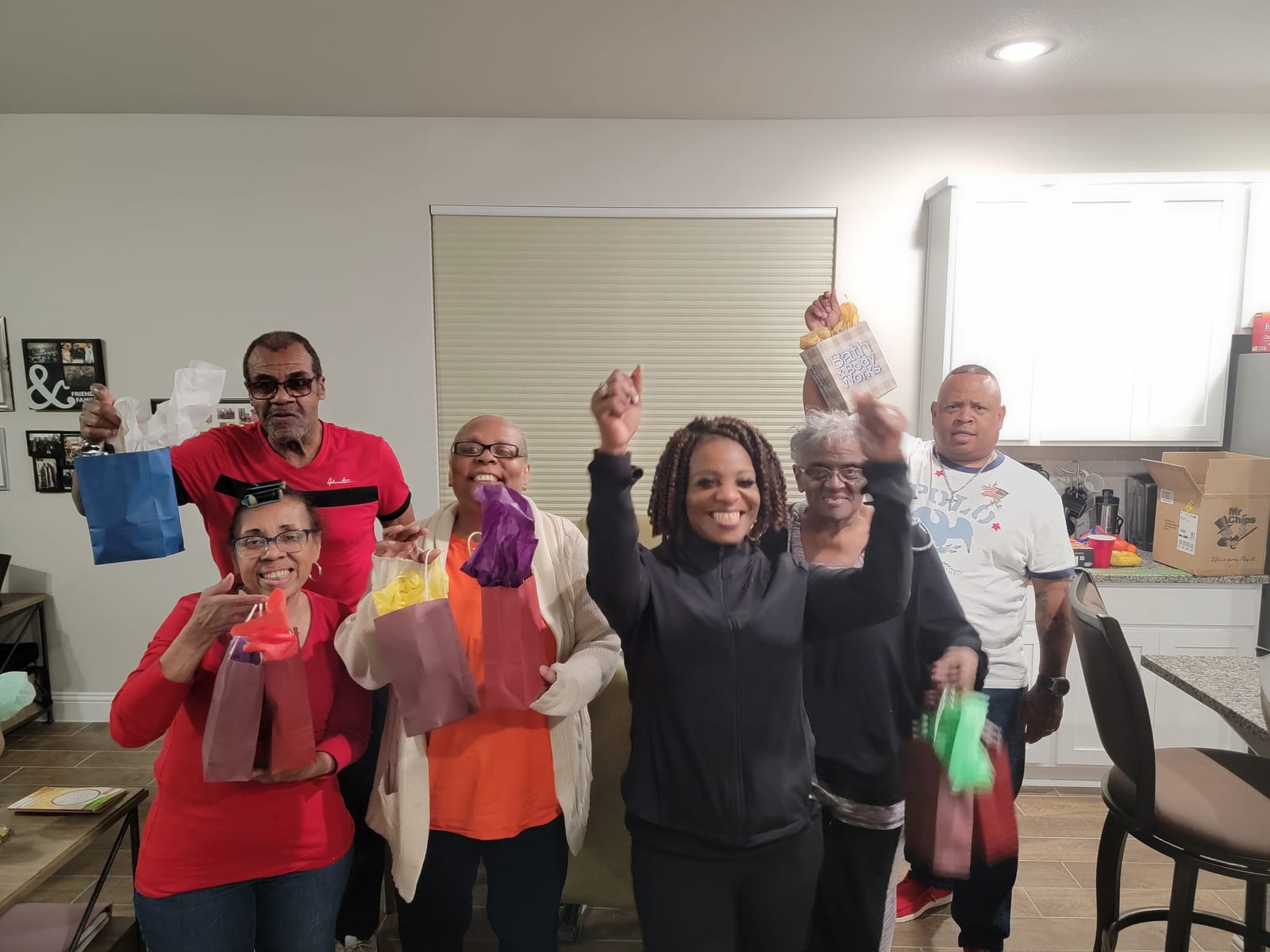 A group of seniors cheering and holding up their gift bags